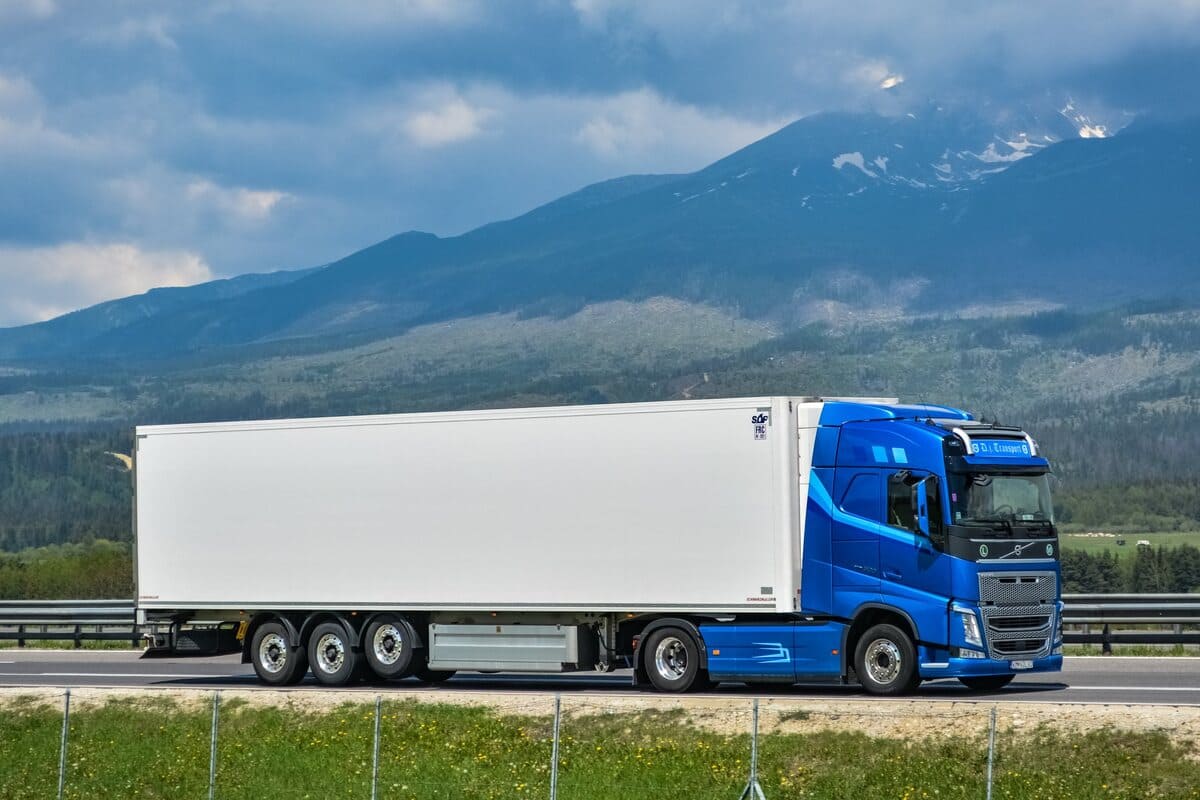 Volvo FH4 - 2025 TOP - sinine veok valge haagisega, taustal mäed