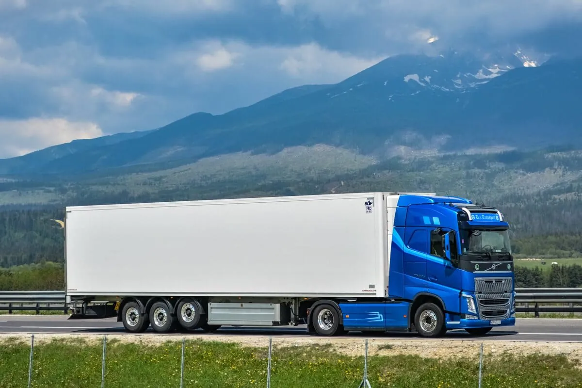 Volvo FH4 - 2025 TOP - sinine veok valge haagisega, taustal mäed